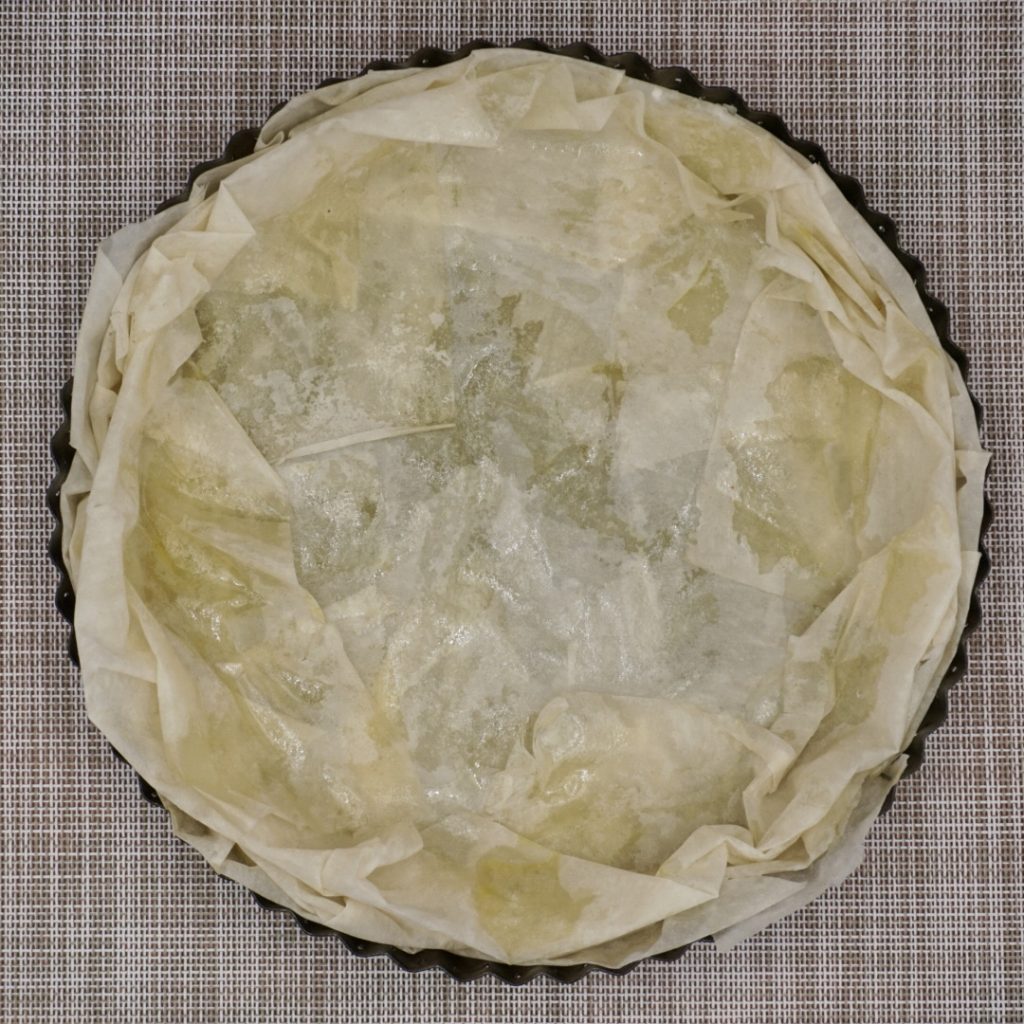 Flan dish lined with three sheets of filo pastry