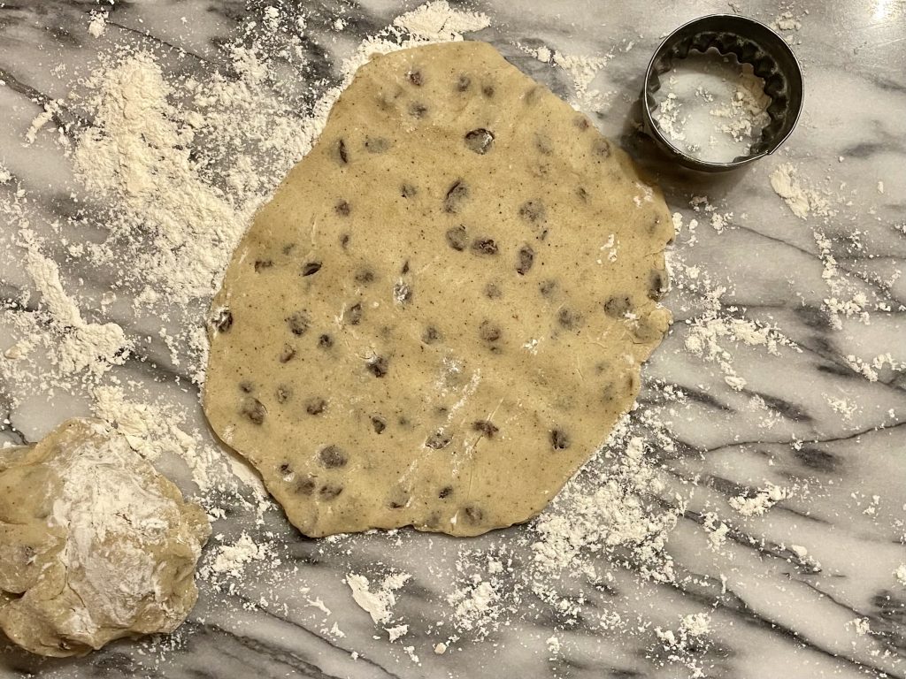 Biscuit dough rolled out on a marble pastry board. 