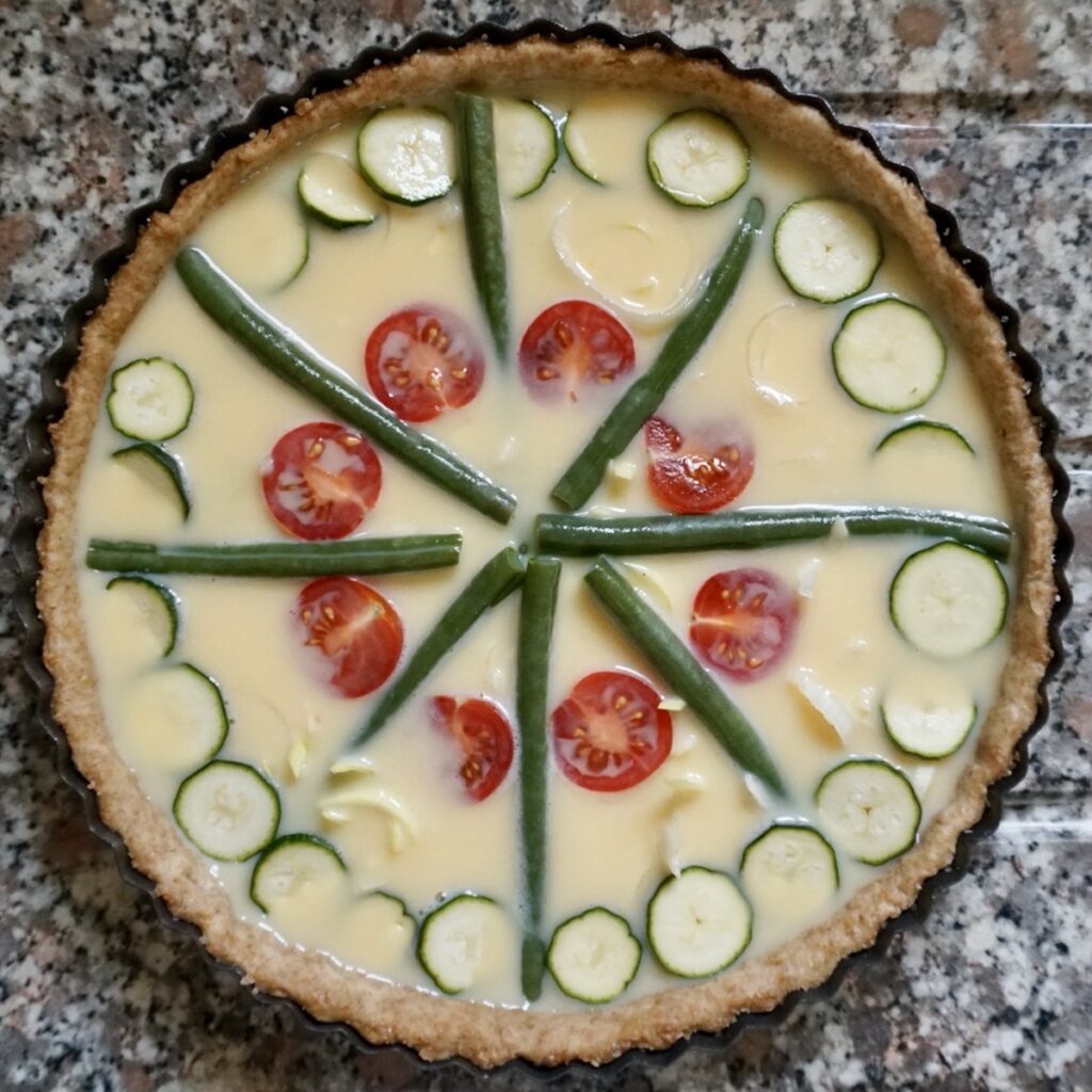 An unbaked vegetable quiche. 