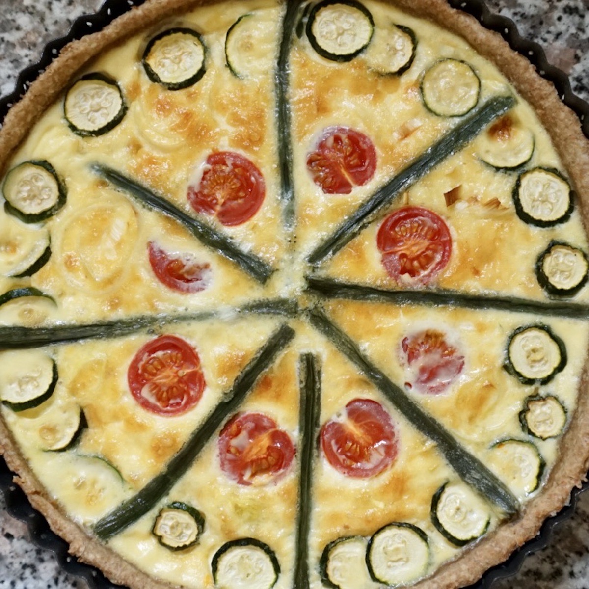 A decorative quiche made using summer vegetables.