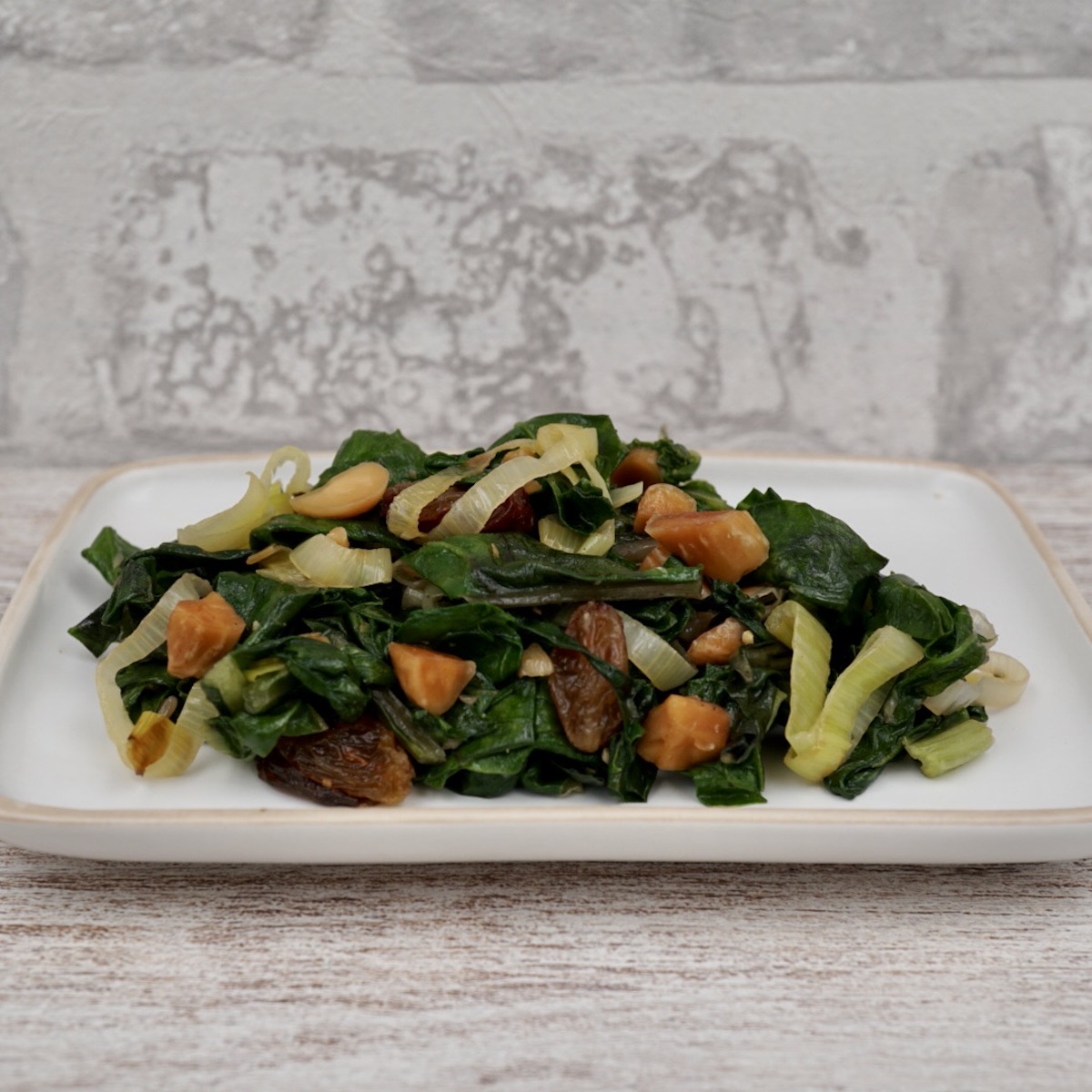 Swiss chard with almonds and raisins on a serving plate