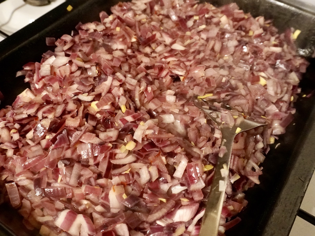 Chopped red onions in a roasting tin