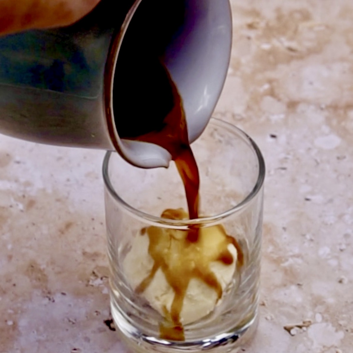 Pouring coffee over ice cream to prepare affogato