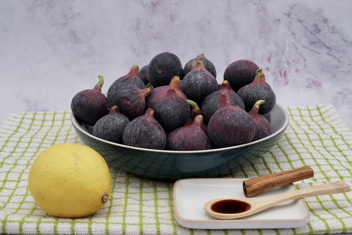 A bowl of figs, lemon, cinnamon stick and vanilla extract