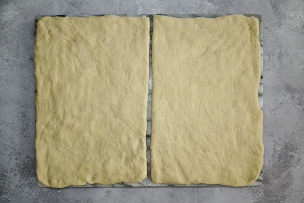 A rectangle of bread dough cut in half