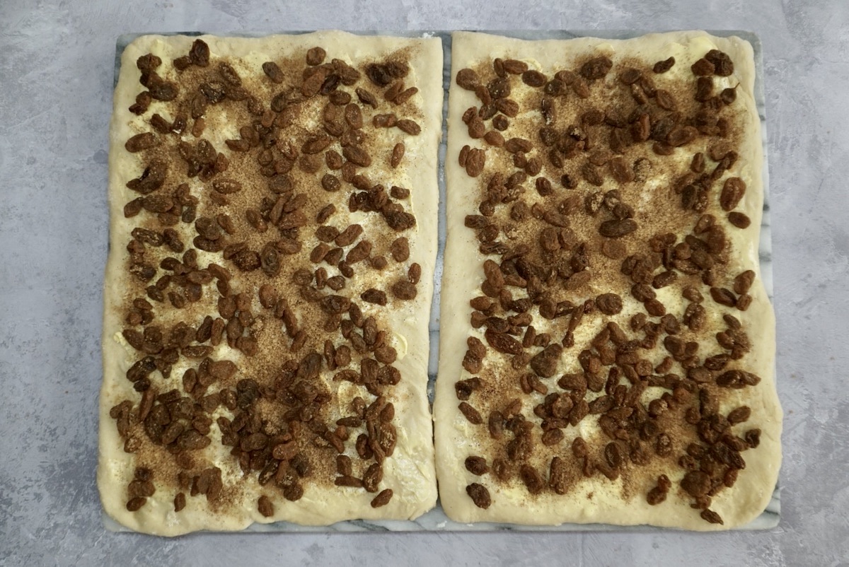 Bread dough covered with raisins, cinnamon and sugar