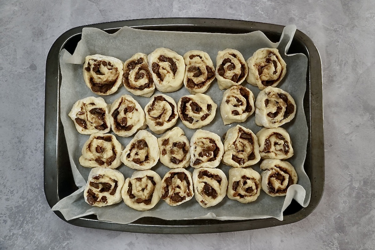 Unbaked cinnamon rolls in a tin