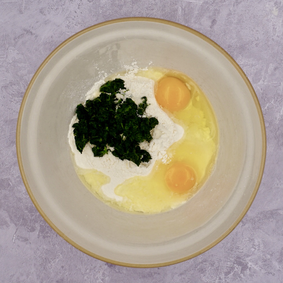Flour, eggs and spinach in a bowl
