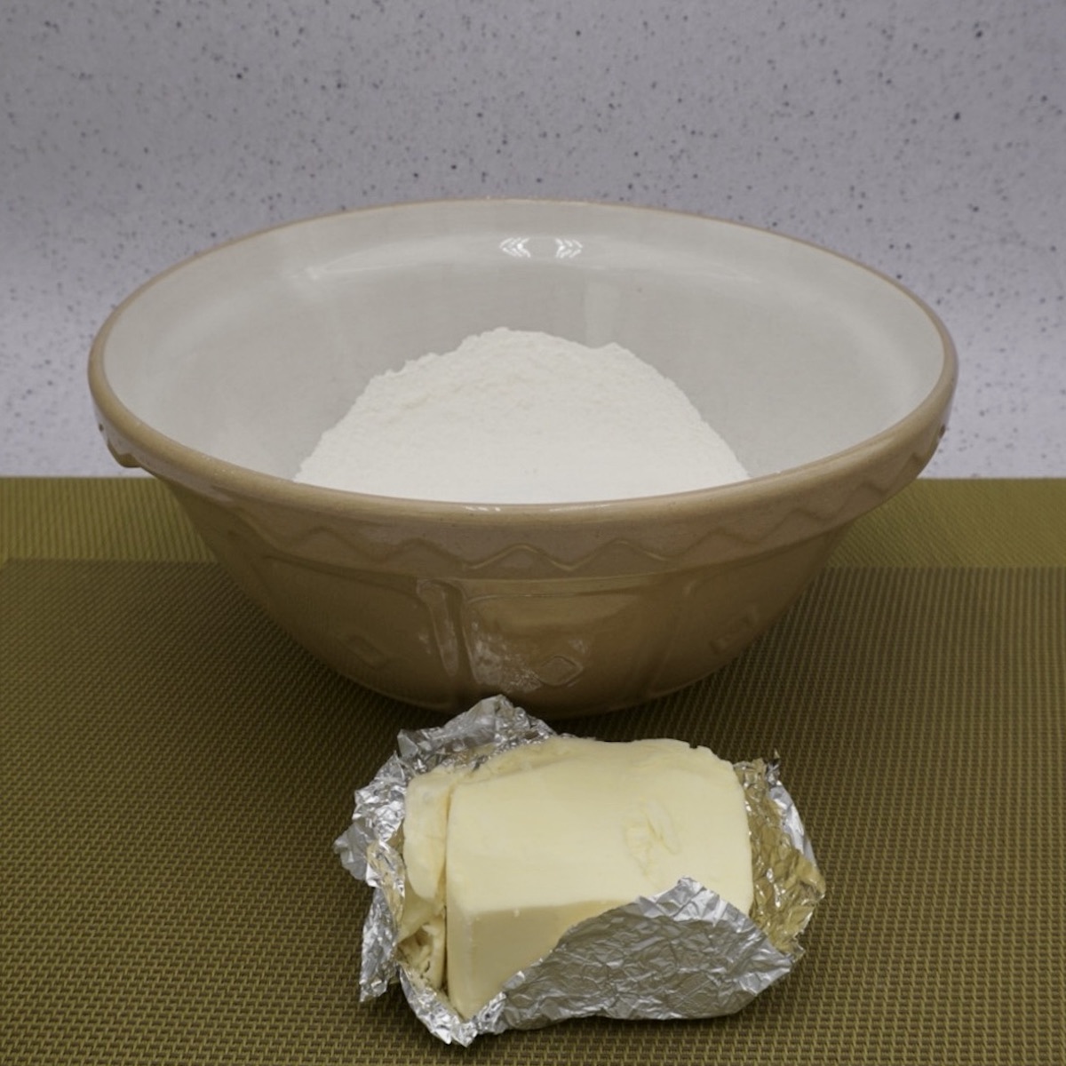 A bowl of flour and a block of butter