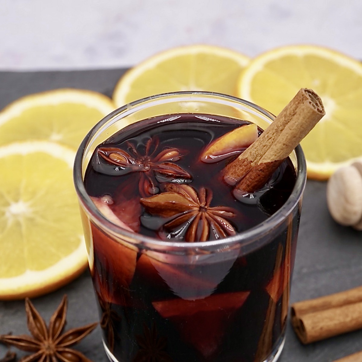 A glass of mulled wine with garnishes