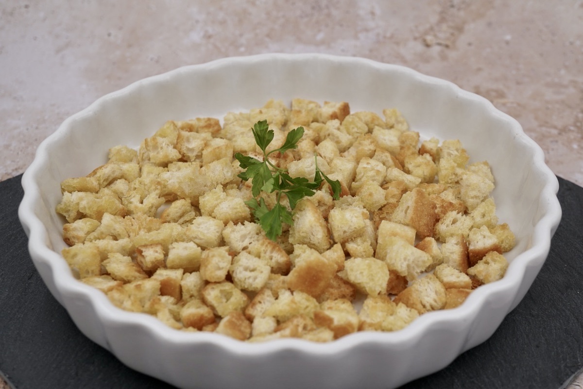 A bowl of homemade croutons with garnish
