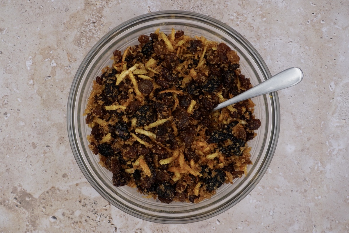 A bowl of dried fruit, citrus zest and sugar. 