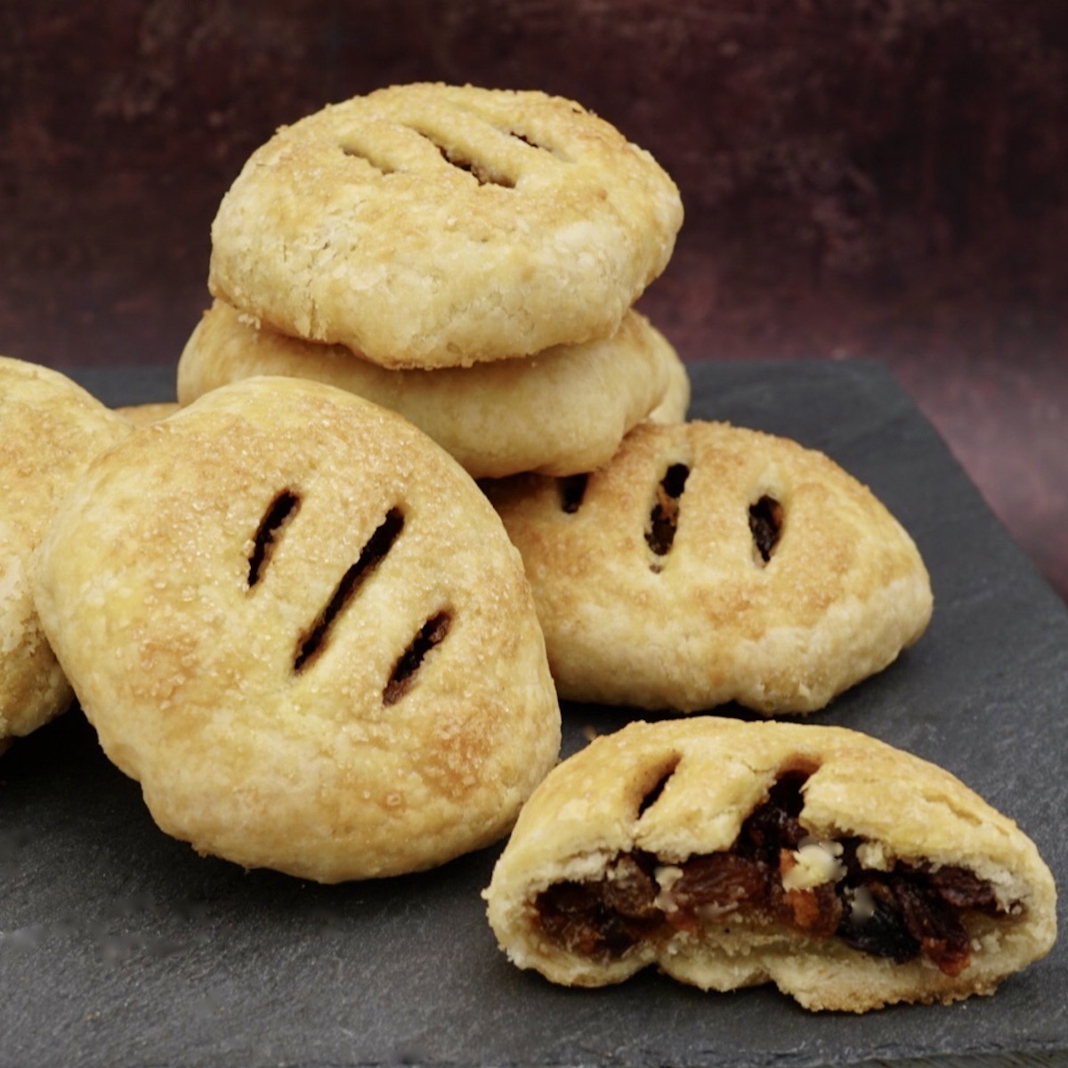 A pile of Eccles cakes including one cut in half.