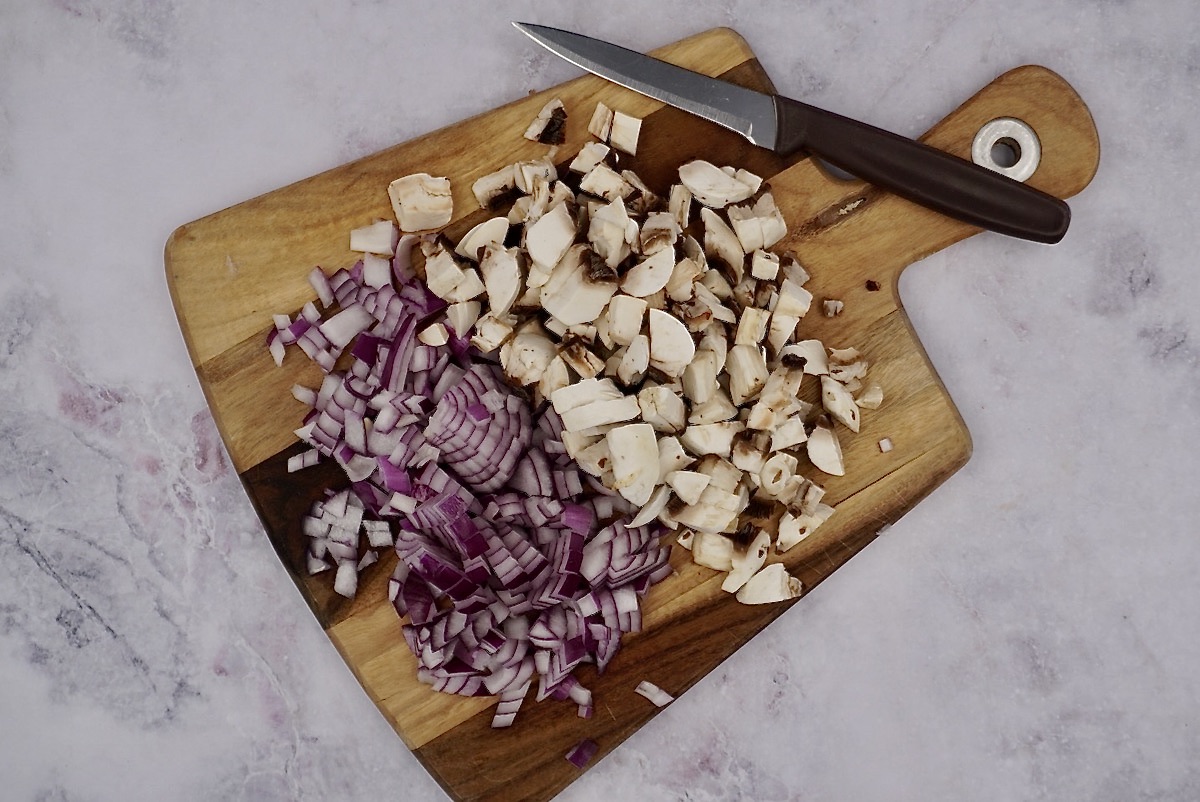 Chopped onion and mushrooms on a board