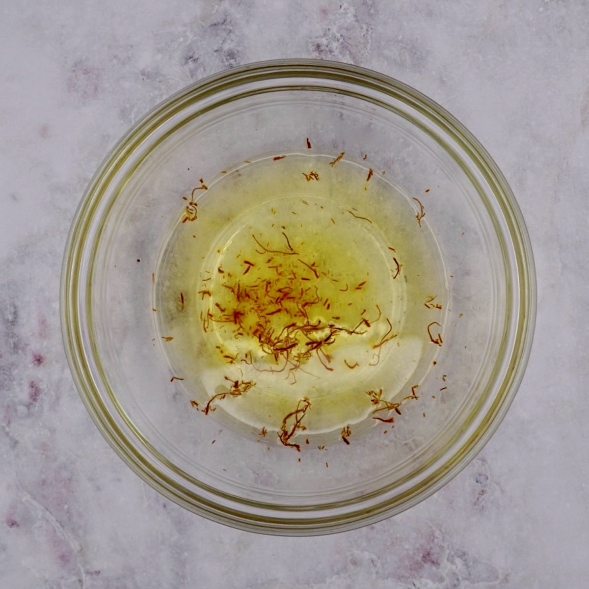 A bowl of saffron threads in water