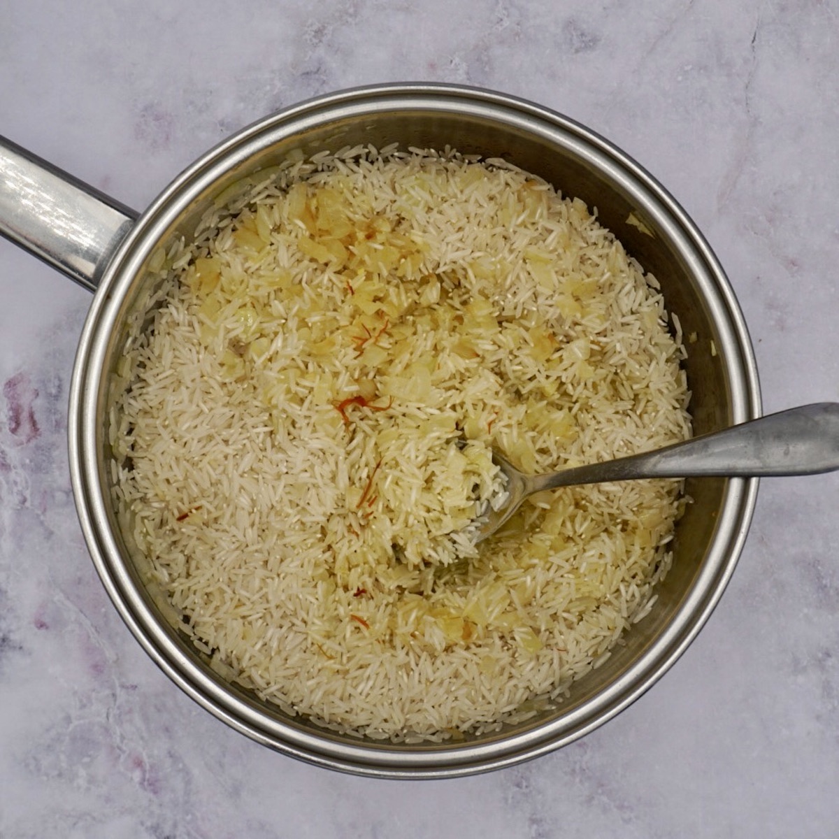 Ingredients for saffron rice in a pan