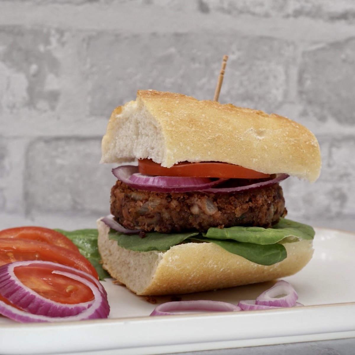 A spicy bean burger in a bread bun with garnish