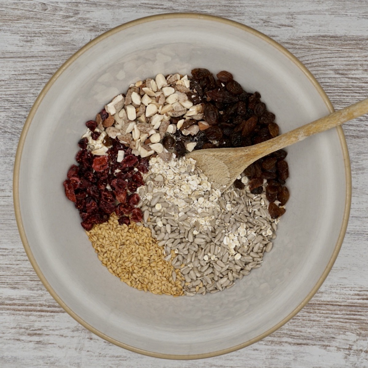 Mixing bowl with oats, dried fruit, nuts and seeds.