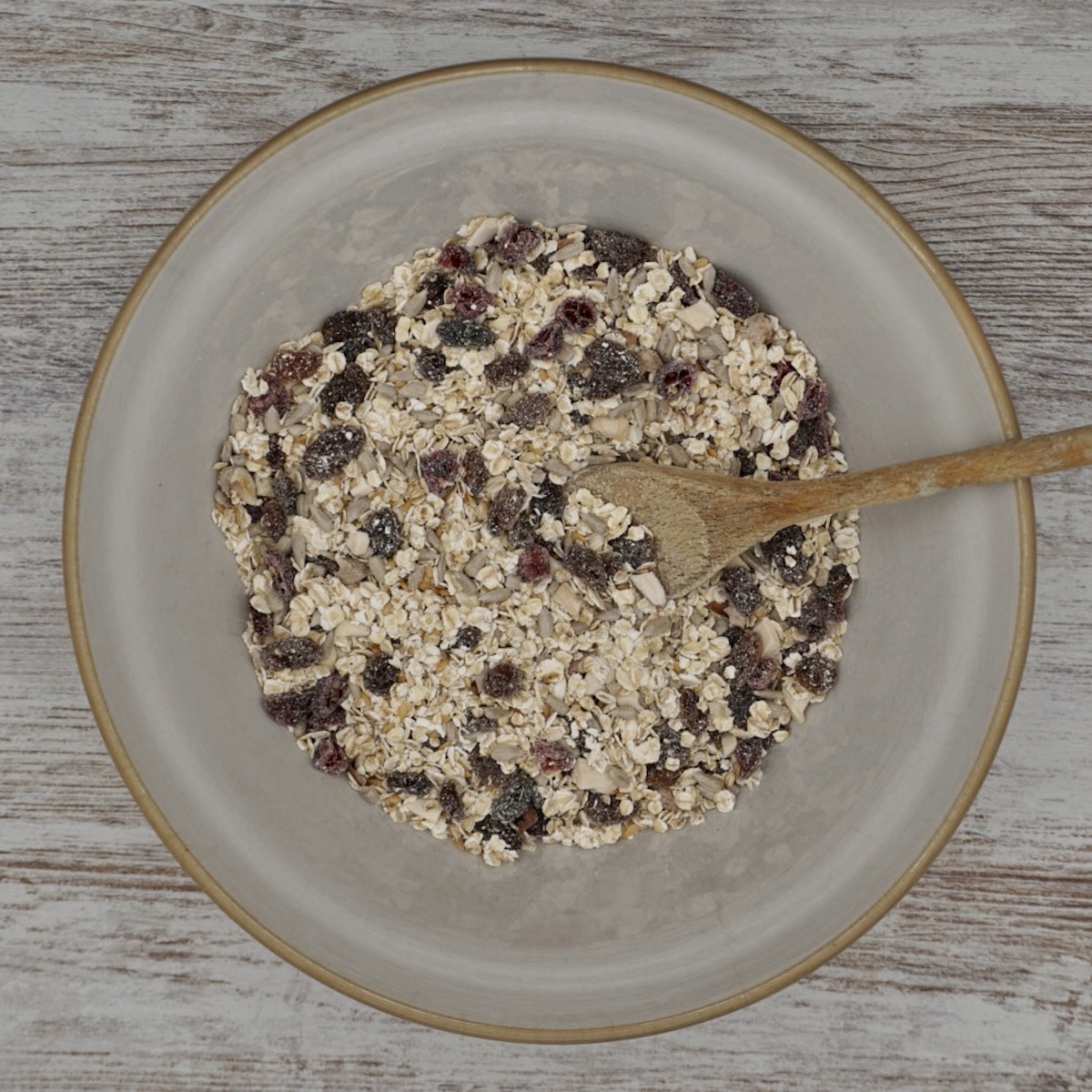 Mixing bowl with oats, dried fruit, nuts and seeds.