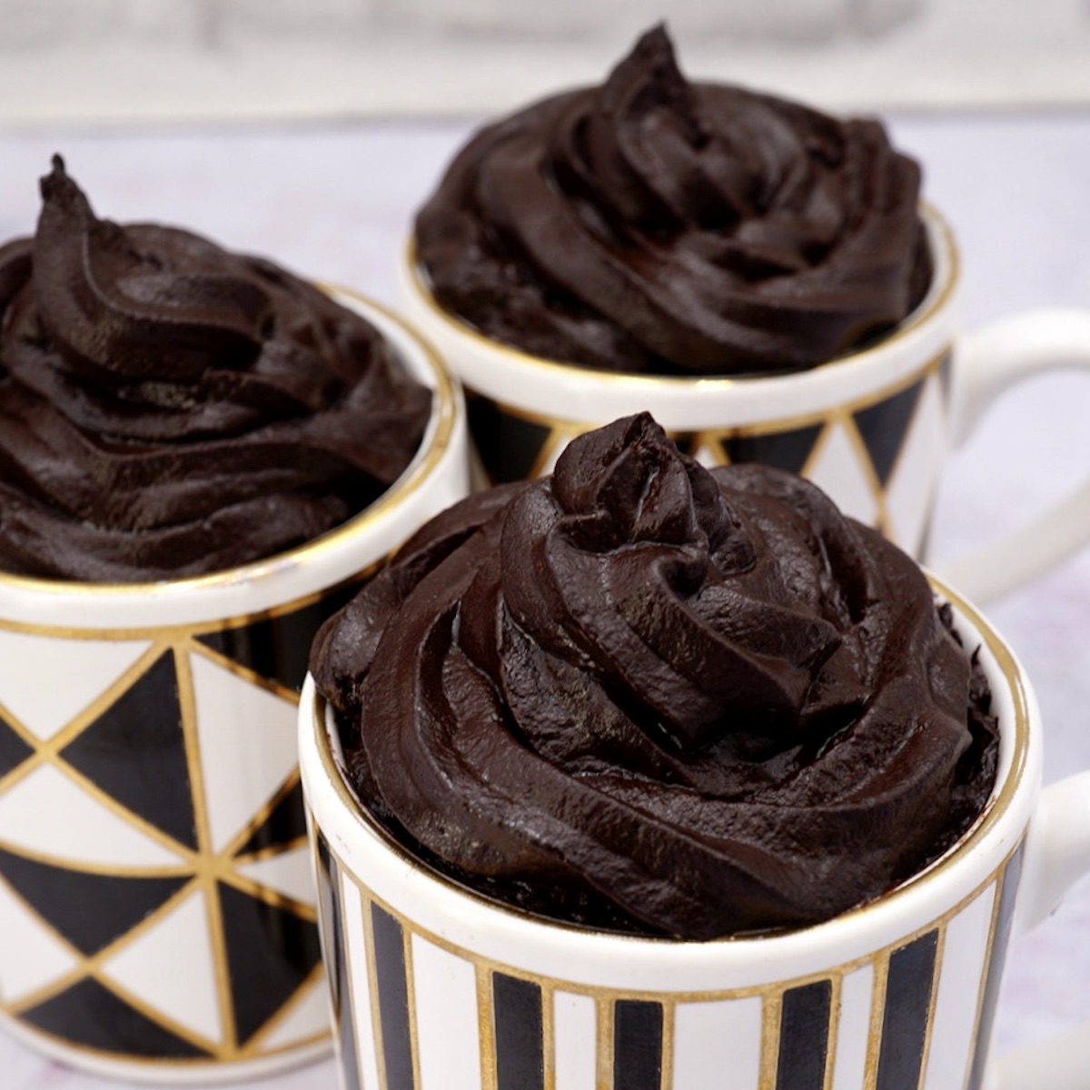 Three cups containing avocado chocolate mousse.