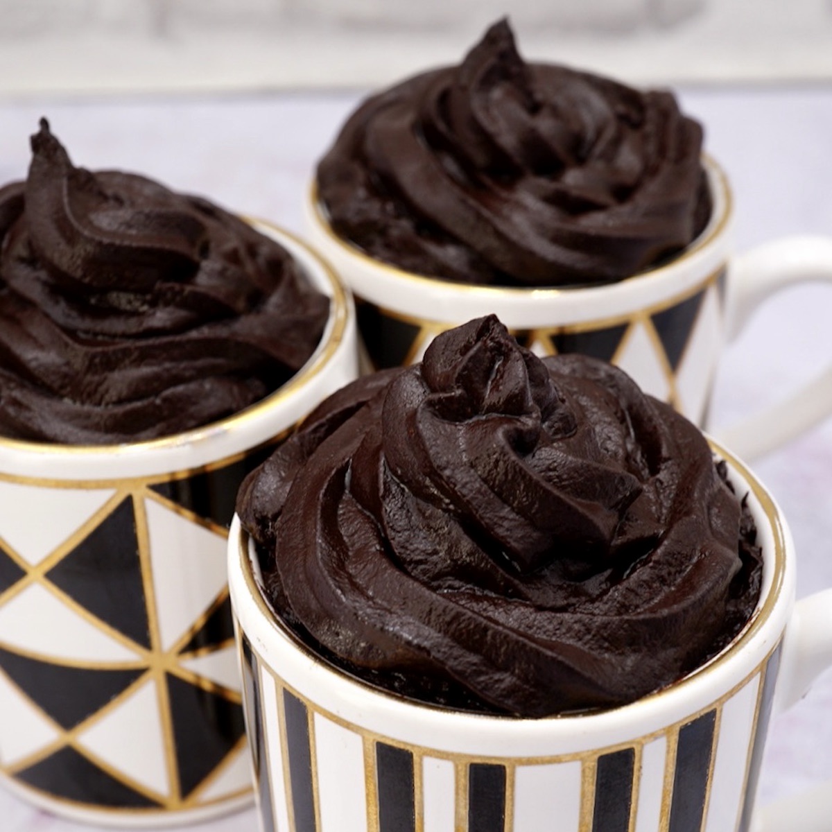 Three espresso cups containing chocolate mousse.