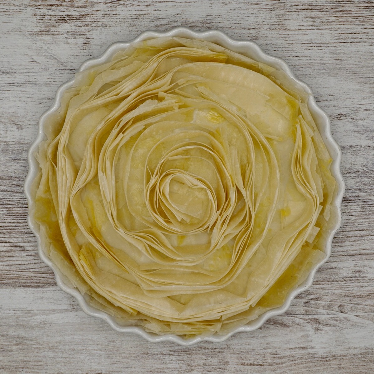 Filo pastry arranged in a circular dish to make a crinkle tart.