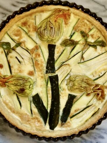 Courgette tart decorated with courgette flowers.