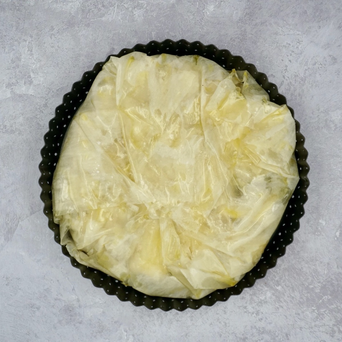 An unbaked filled filo pastry parcel.