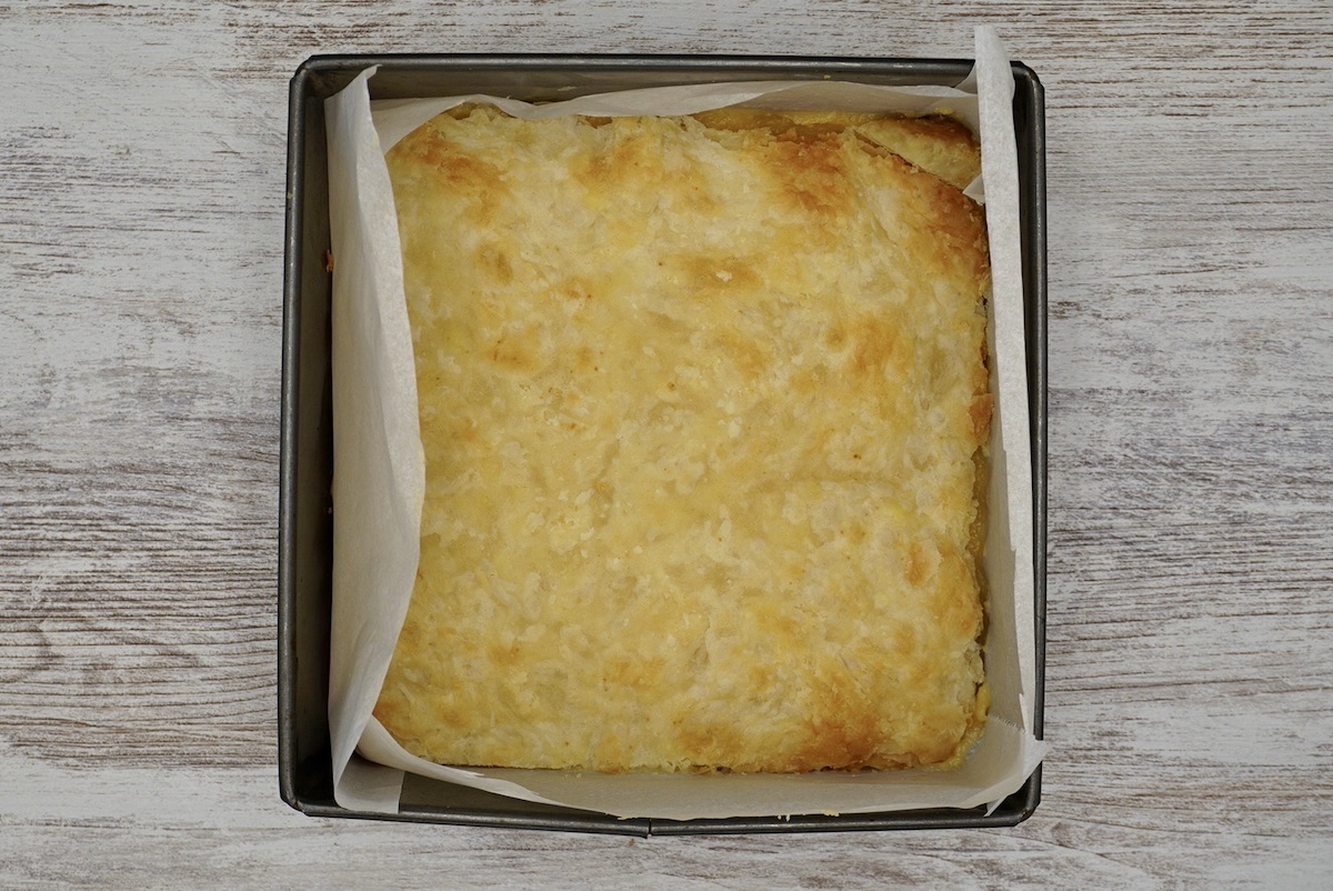 A square tin with cooked pastry inside.
