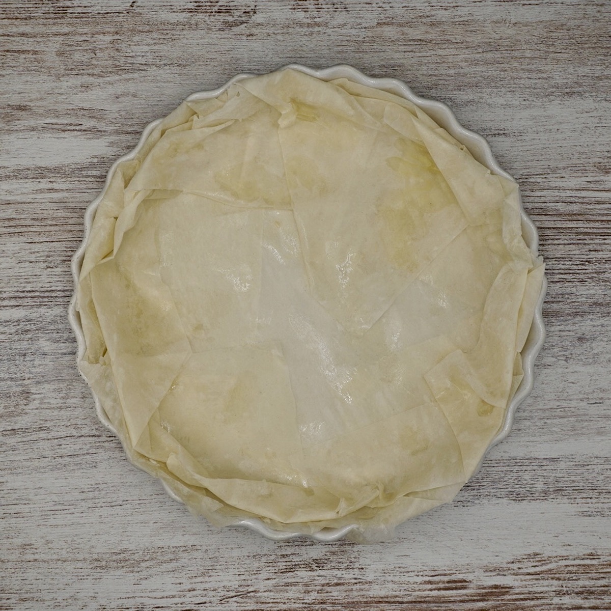 A tart dish lined with filo pastry.