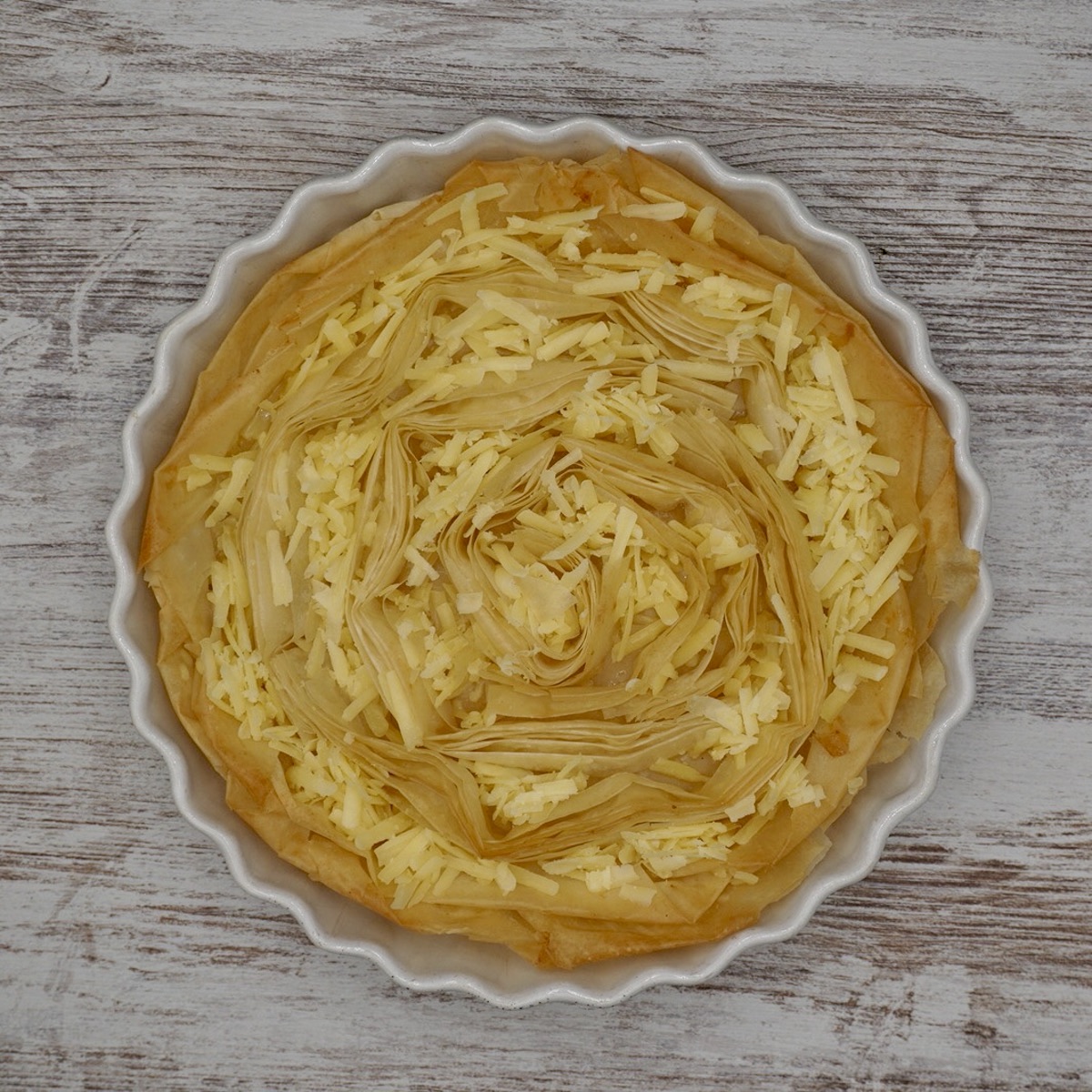 A filo tart case with grated cheese.