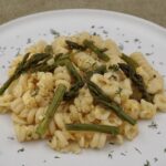 A plate of pasta with scrambled eggs and asparagus.