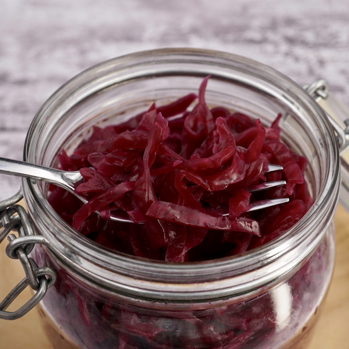 A forkful of red cabbage sauerkraut over an open jar, 