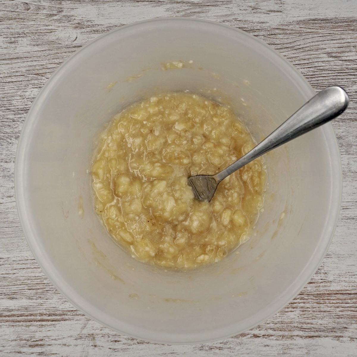 Mashed banana in a bowl with a fork.
