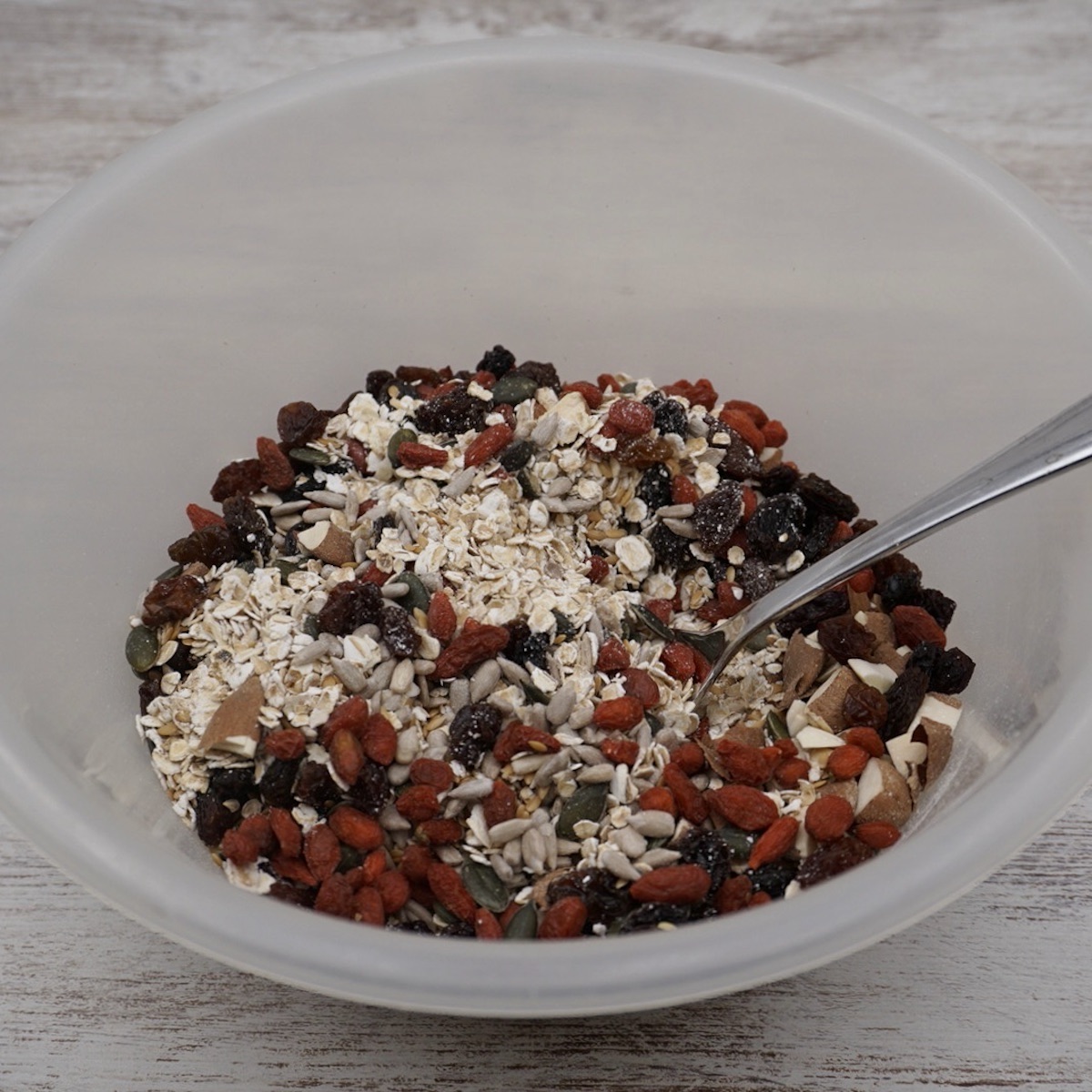 A bowl containing oats, dried fruit, nuts and seeds.