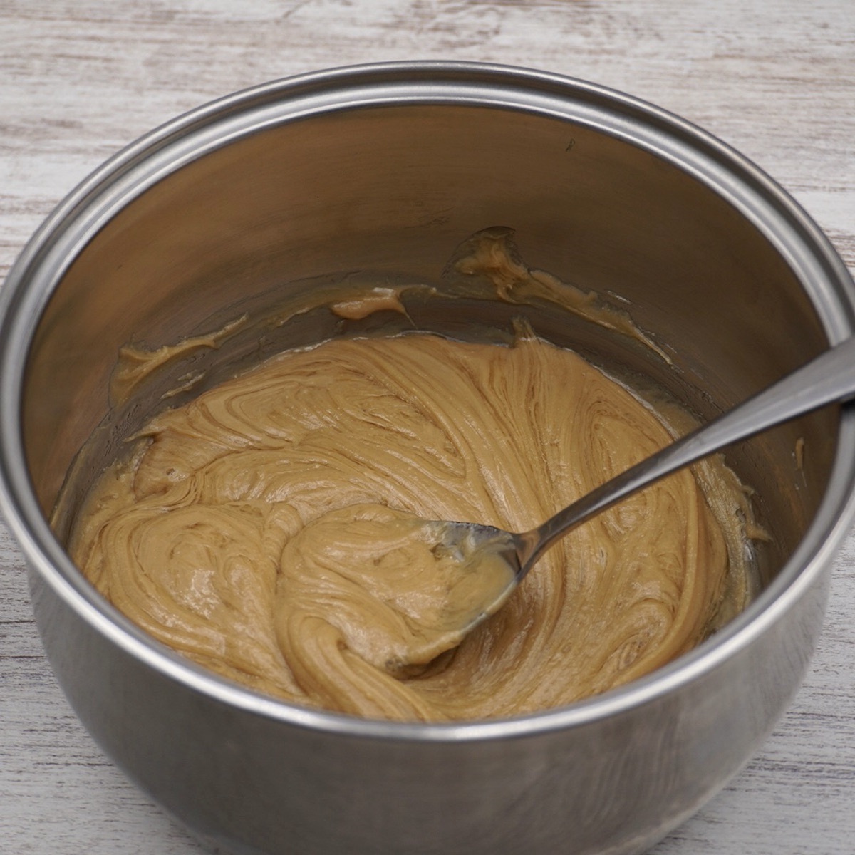 A pan containing peanut butter and honey and a spoon.