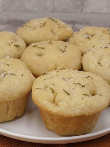 Several individual focaccia rolls on a plate.