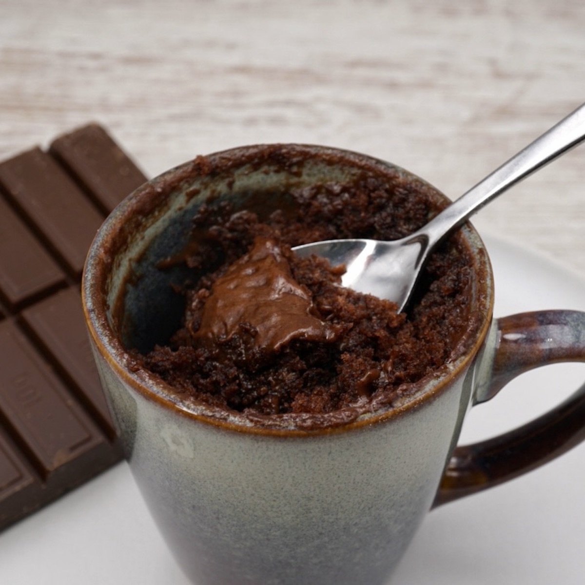 A chocolate mug cake with a spoon. 
