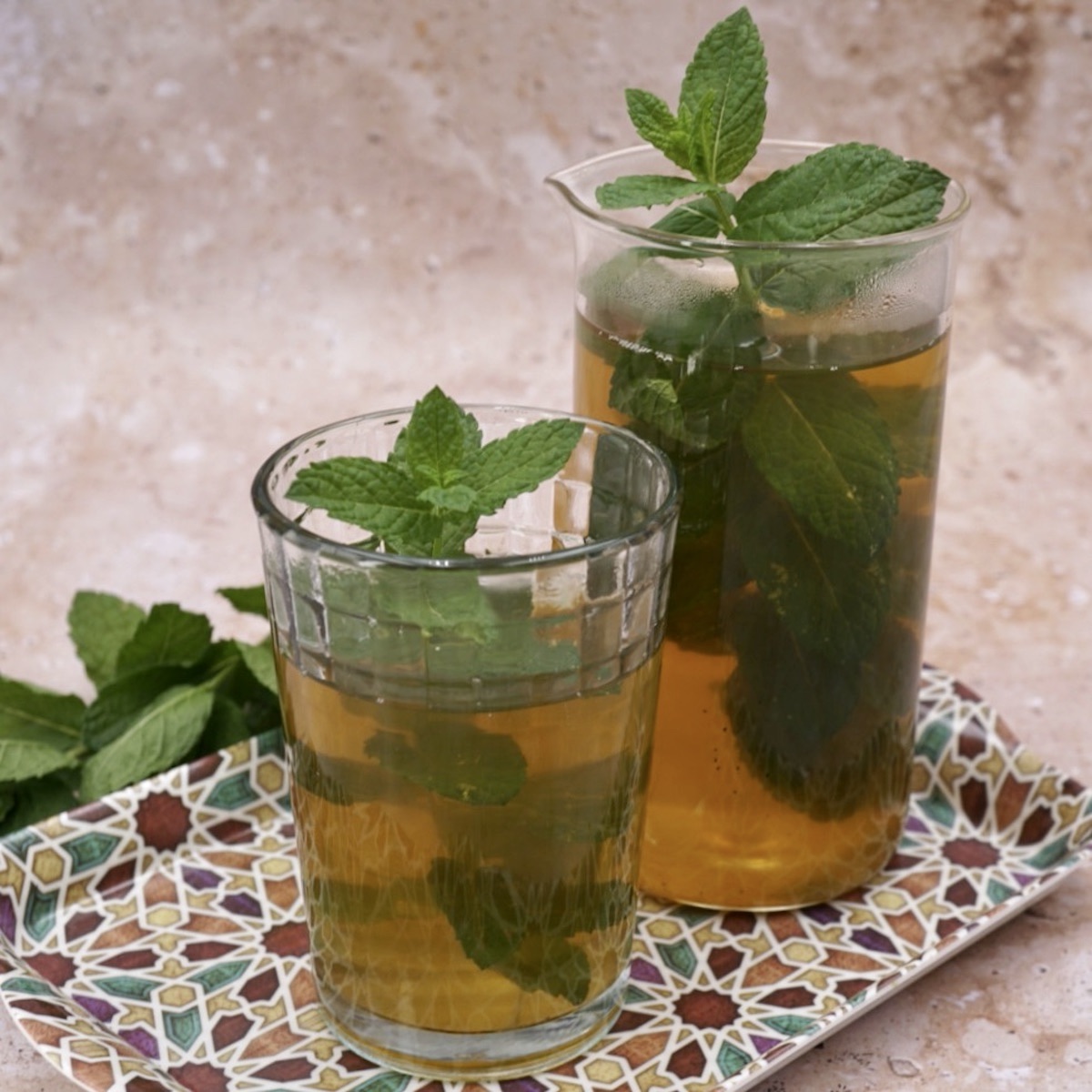 Two glasses of Moroccan mint tea with mint garnish. 
