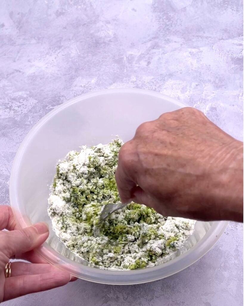 Ingredients for edamame bean fritters being mixed in a bowl.