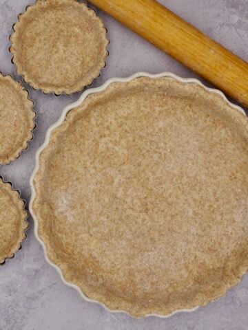 Tart dishes lined with wholemeal pastry.