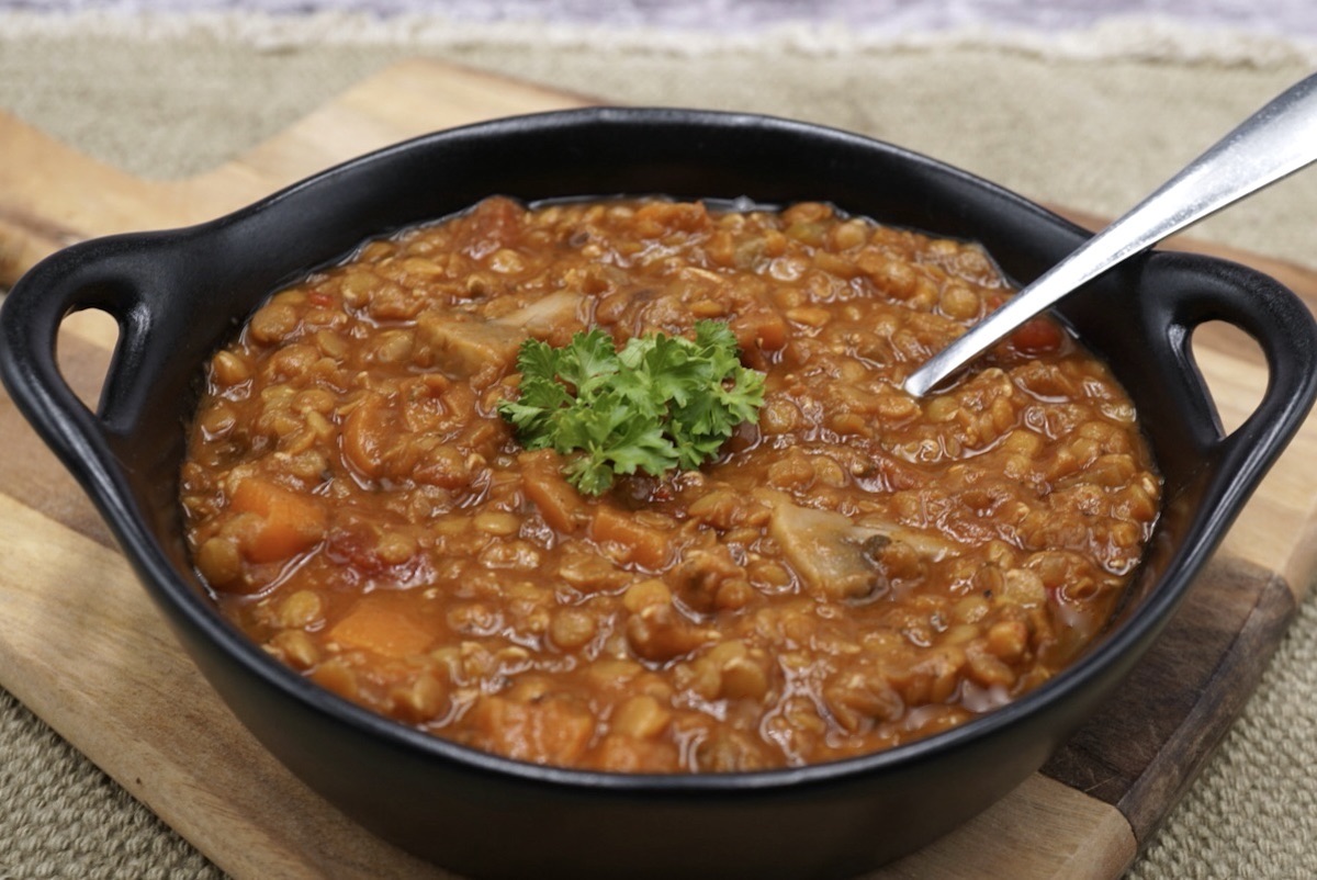 A bowl of lentil ragout with parsley garnish.