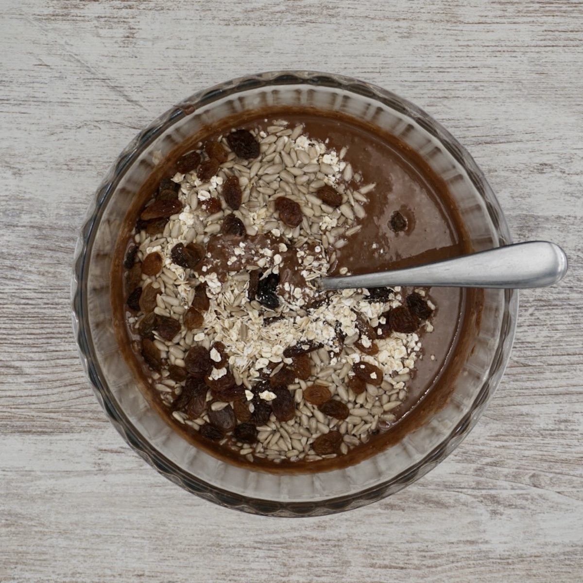 Melted chocolate, seeds and dried fruit in a bowl.