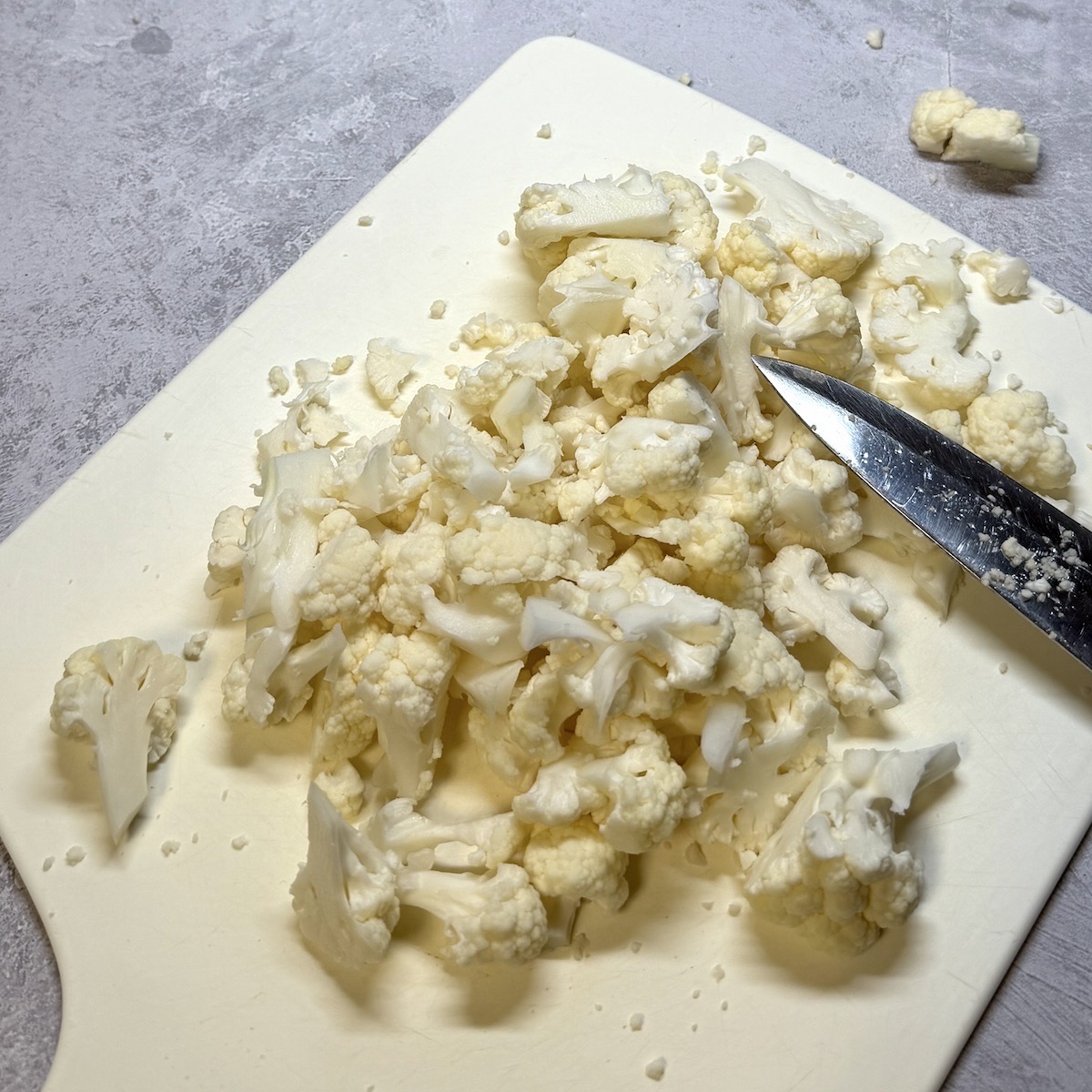 Cauliflower cut into pieces on a board.