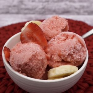 A bowl of strawberry banana sorbet with fruit.