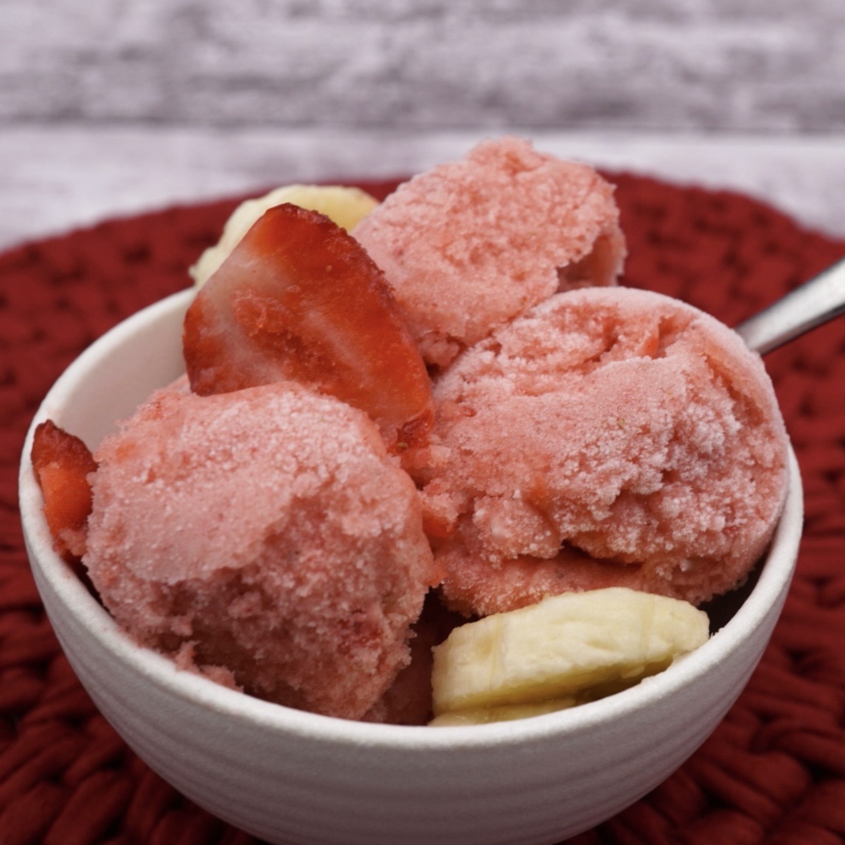 A bowl of strawberry banana sorbet with fruit. 