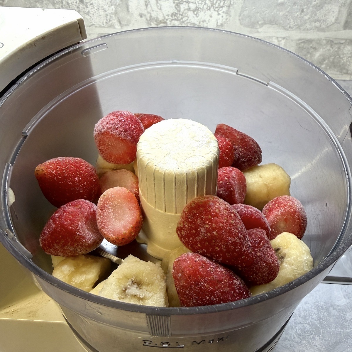 Strawberries and chopped banana in a food processor.
