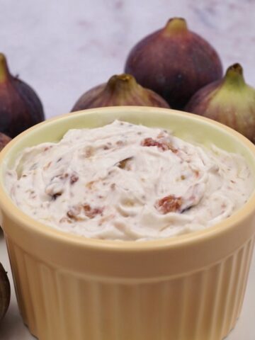 A bowl of fig mousse next to some figs.