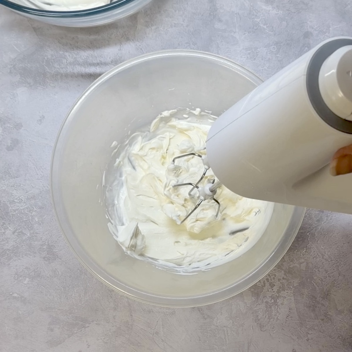 Cream being whipped with an electric mixer.