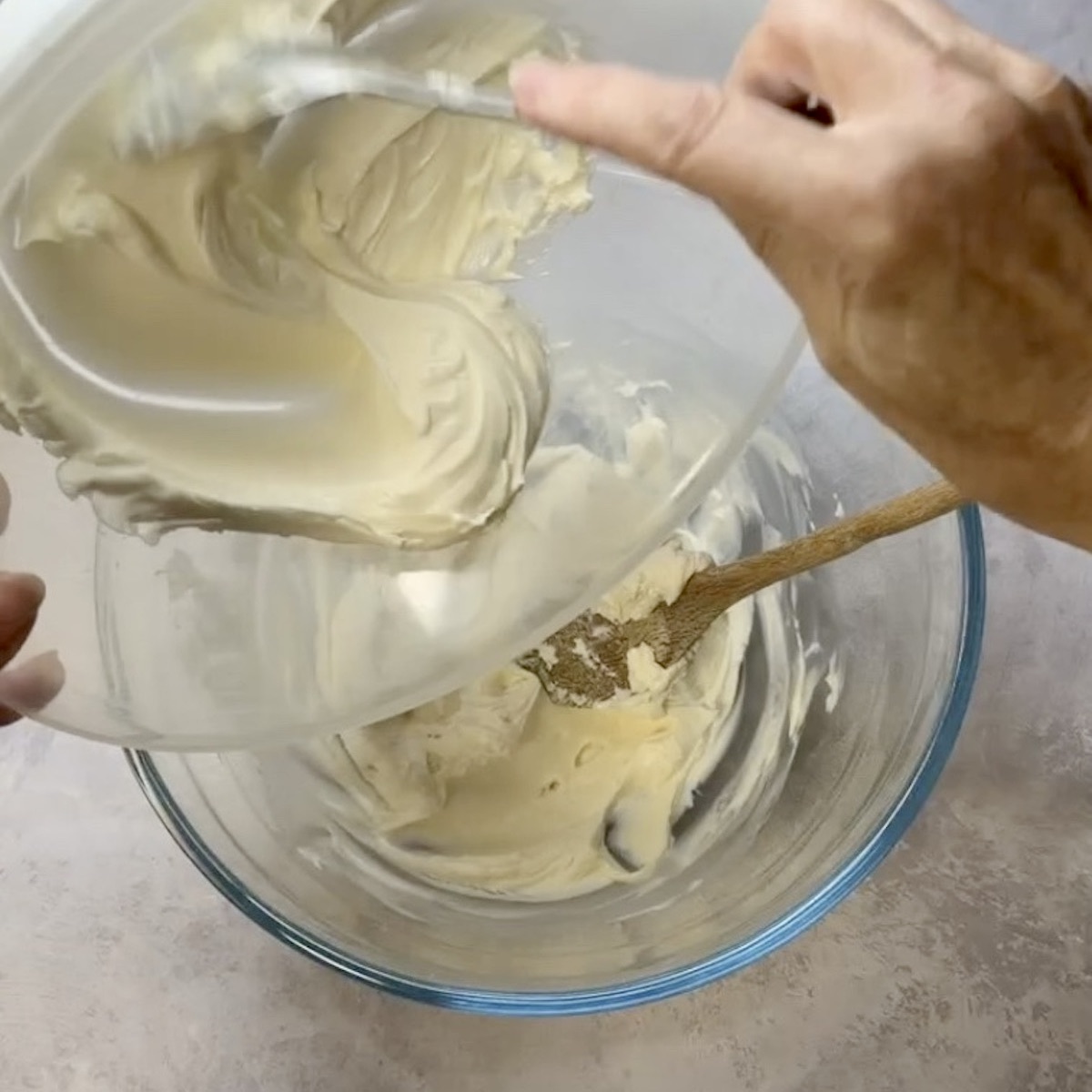 Cream being transferred from one bowl to another.